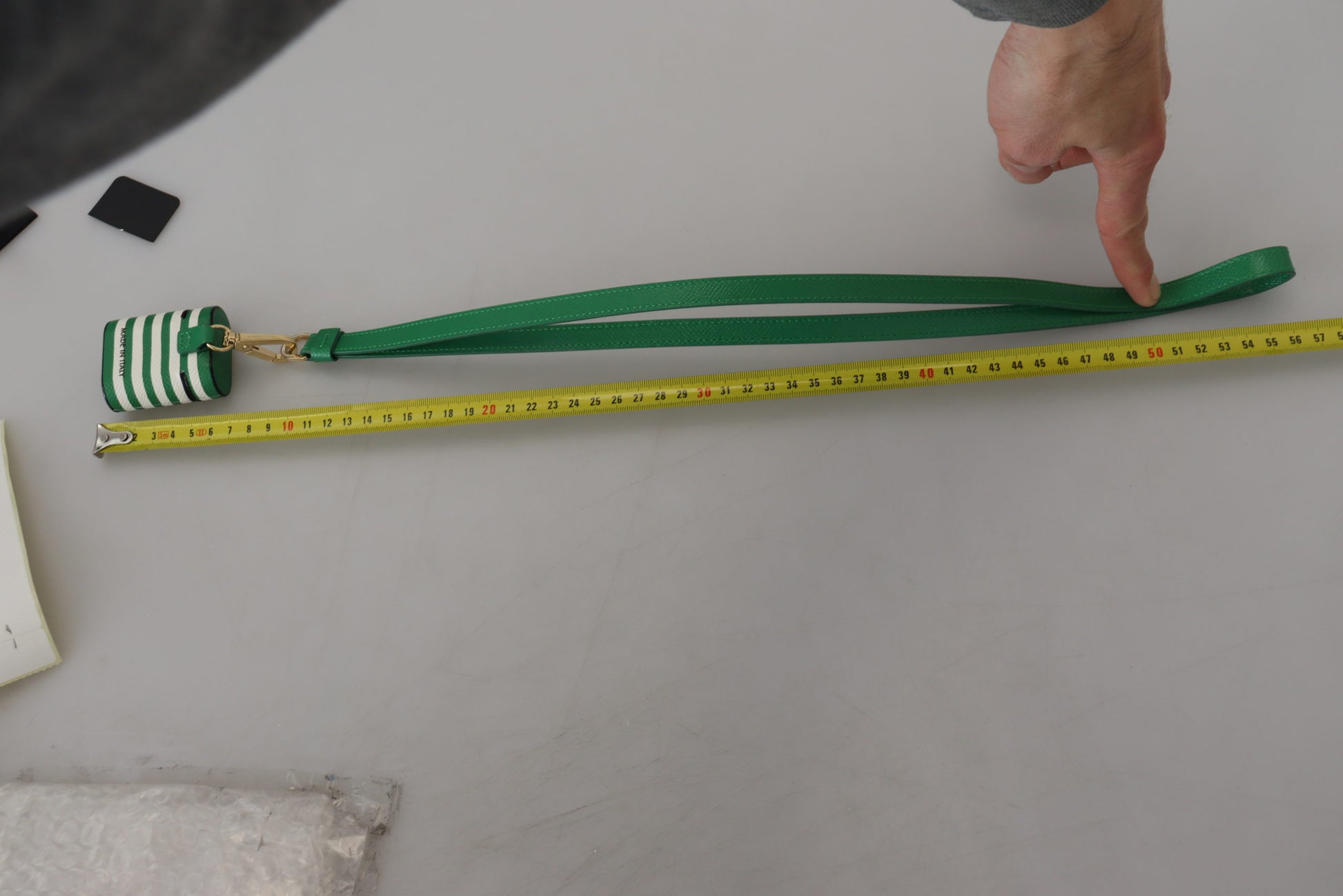 Airpods-Hülle mit grünem Lederband und goldenem Metalllogo