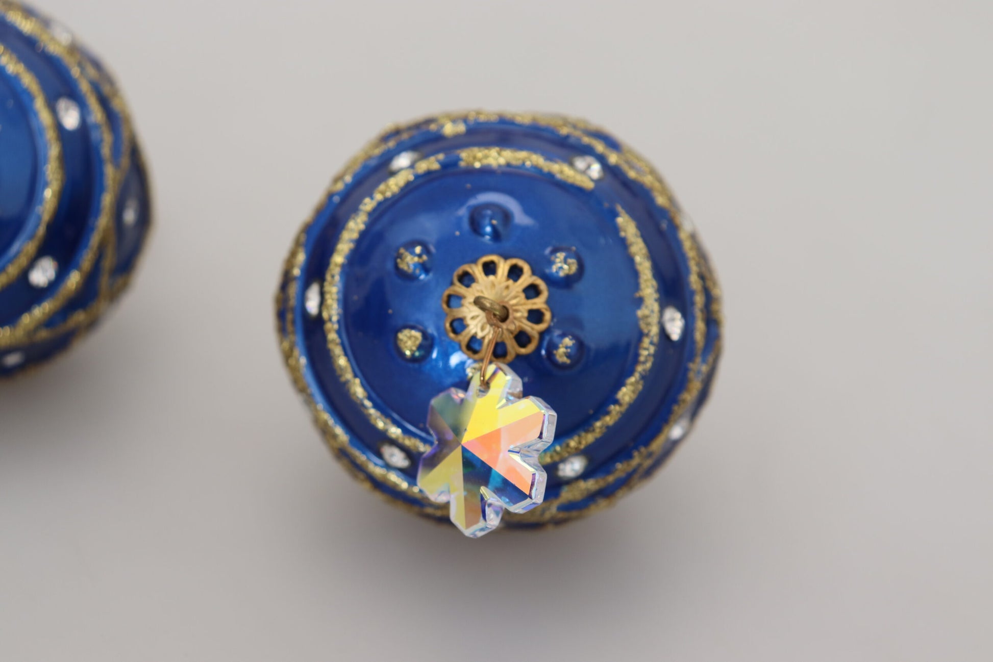 Ohrclips aus Messing in Gold und Blau mit baumelnden Kugeln und Kristallen