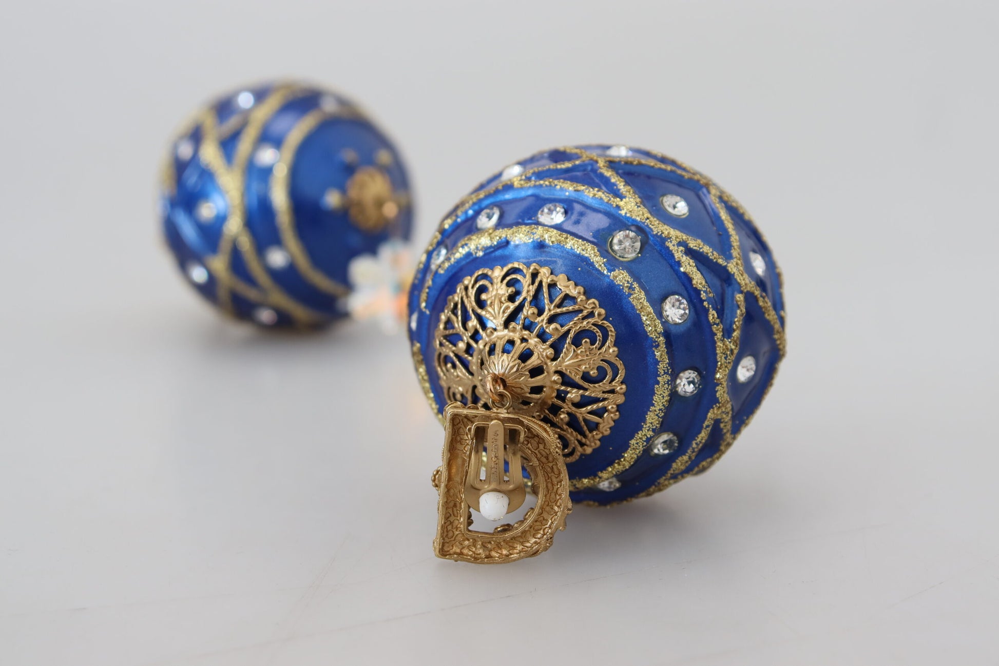 Ohrclips aus Messing in Gold und Blau mit baumelnden Kugeln und Kristallen