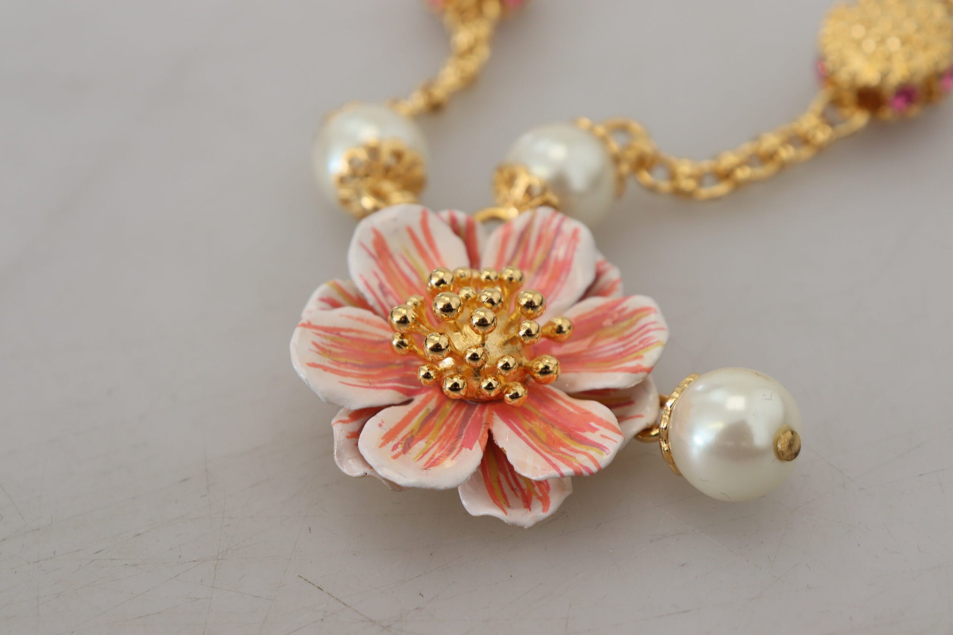 Goldfarbene Halskette mit floralen Kristallen und rosa Verzierung