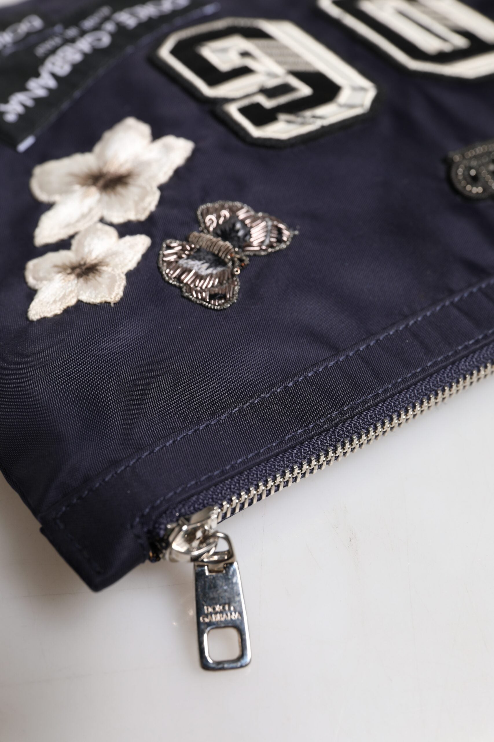 Blaue Clutch mit DG-Logo-Patch und Verzierung