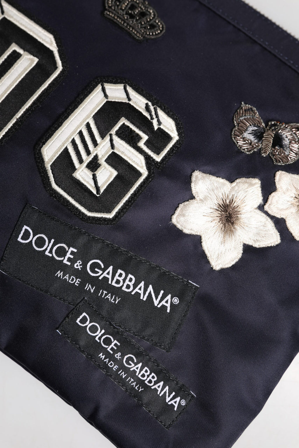 Blaue Clutch mit DG-Logo-Patch und Verzierung