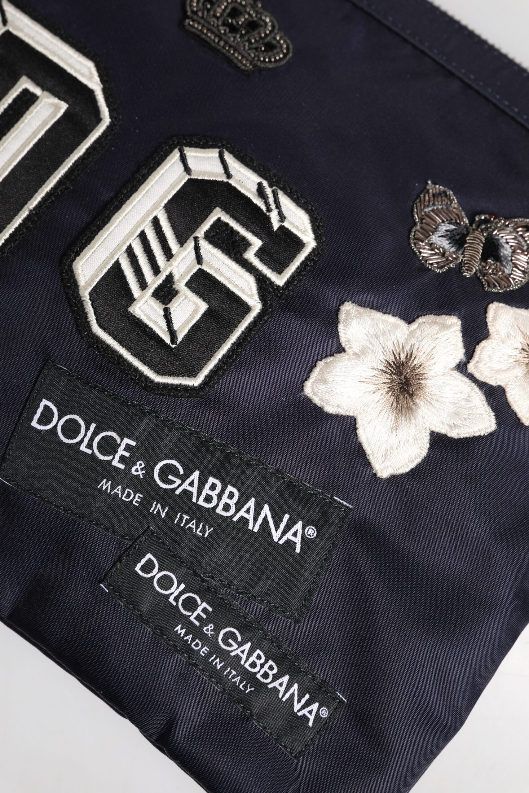 Blaue Clutch mit DG-Logo-Patch und Verzierung