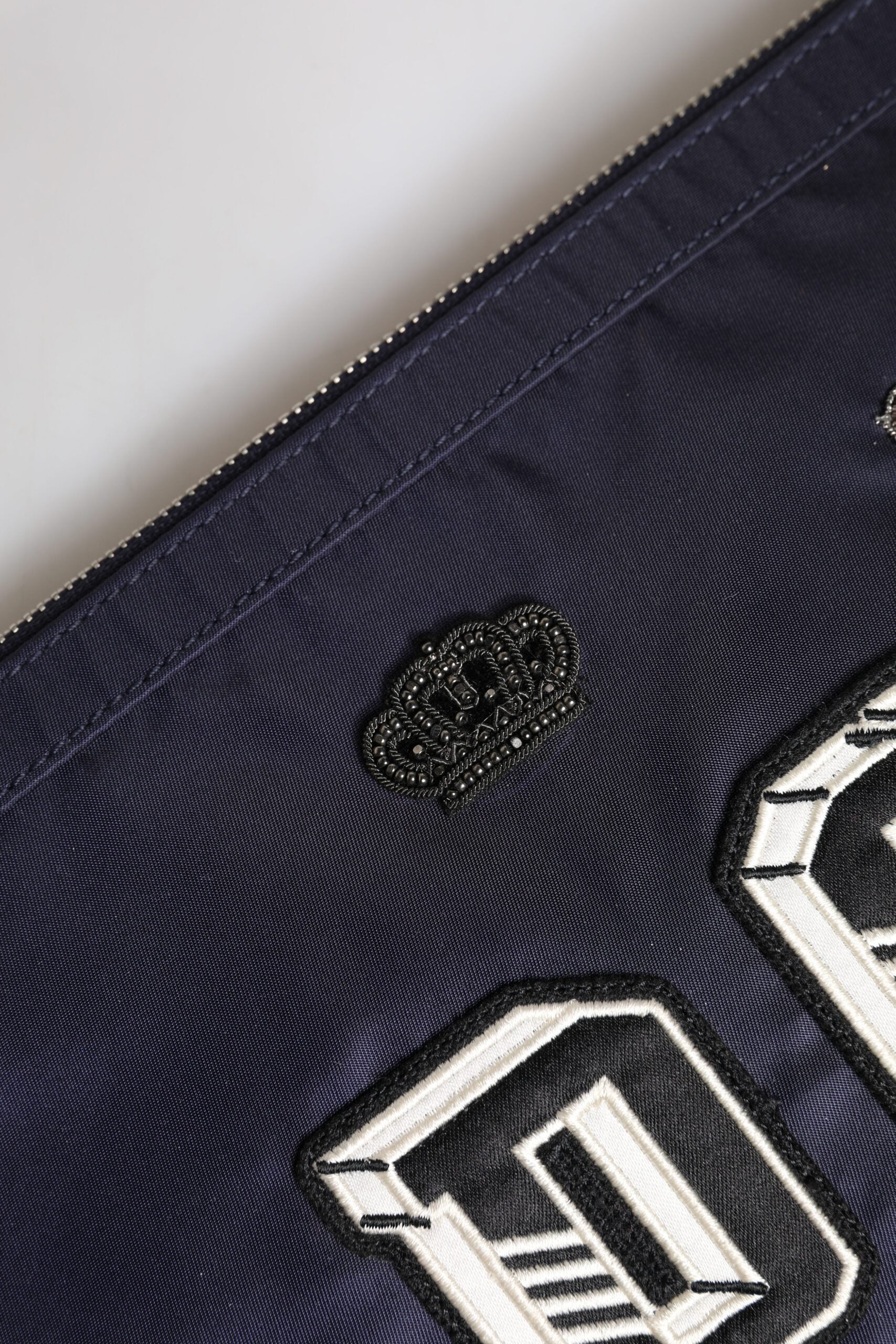 Blaue Clutch mit DG-Logo-Patch und Verzierung