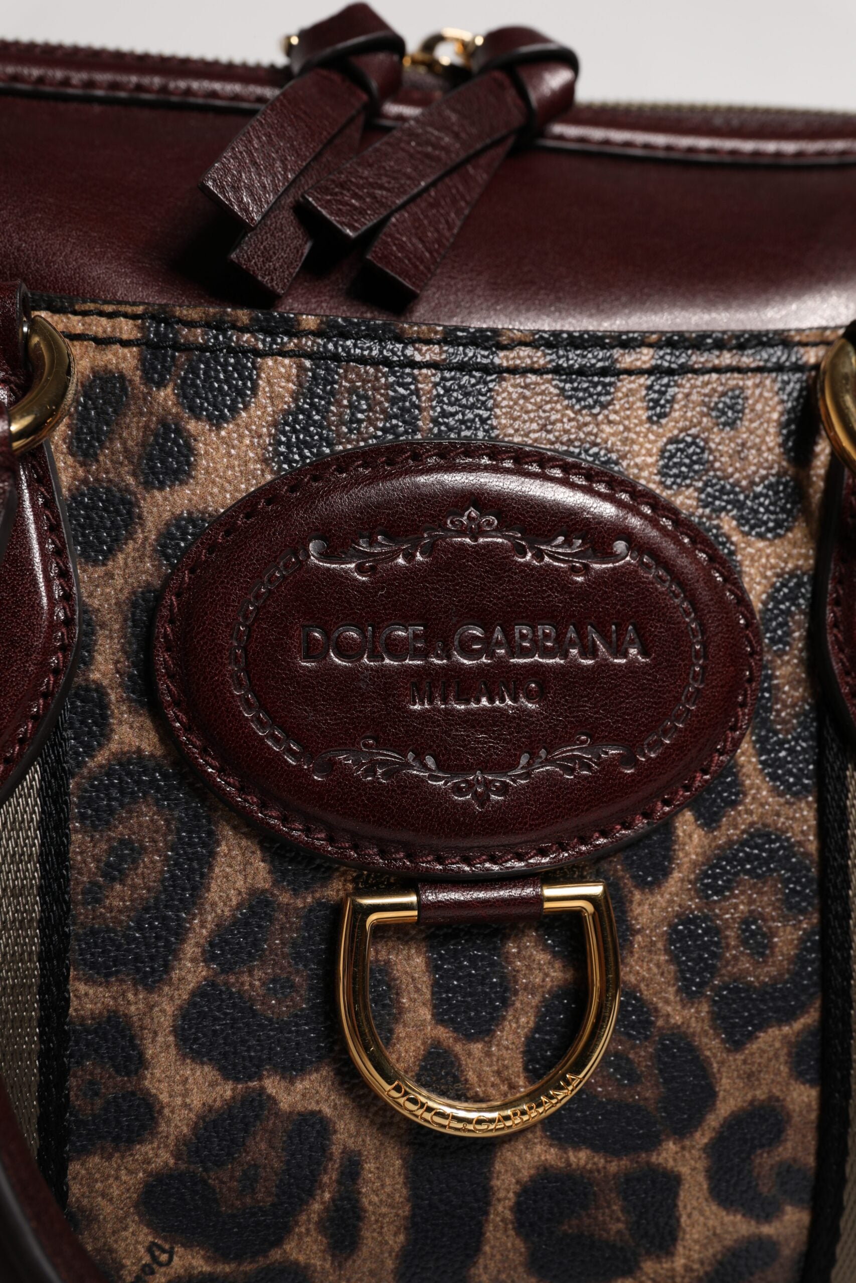 Reisetasche aus braunem Leder mit Schultergurt und Leopardenmuster