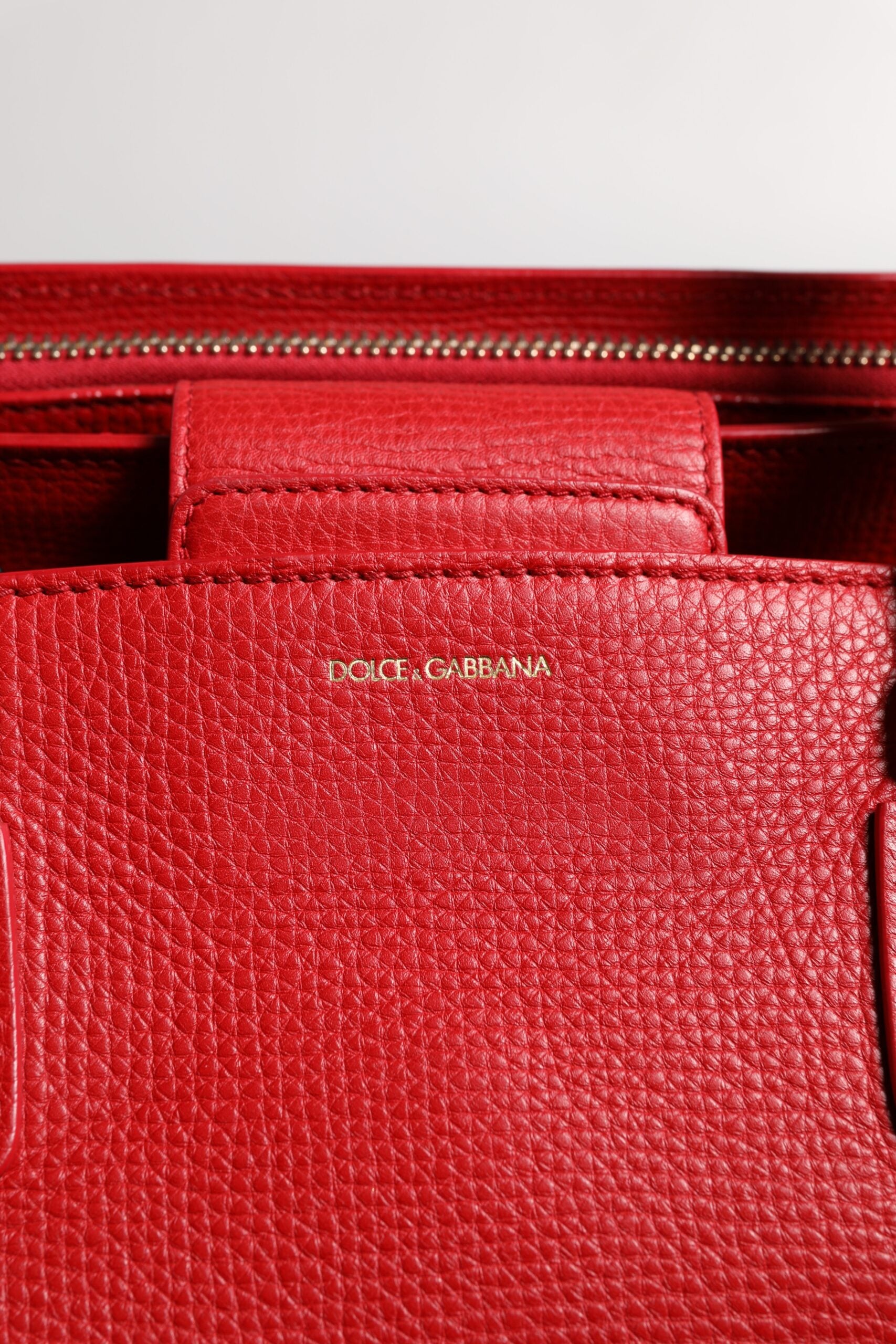 Rote Tasche aus Kalbsleder mit Logo-Schild und Henkel