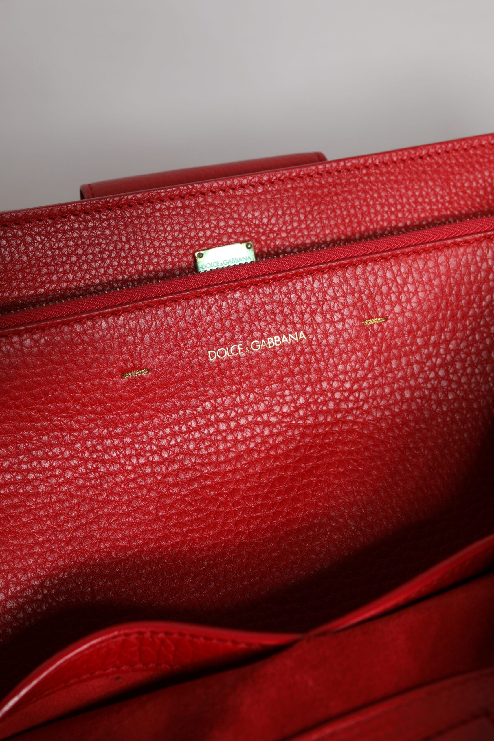 Rote Tasche aus Kalbsleder mit Logo-Schild und Henkel