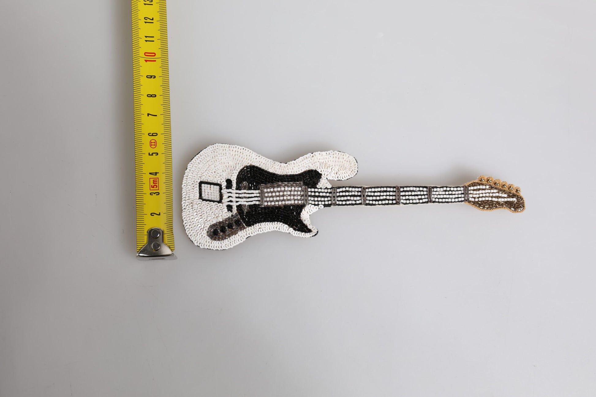 Goldfarbene Gitarren-Brosche mit Logo und Perlen aus Messing
