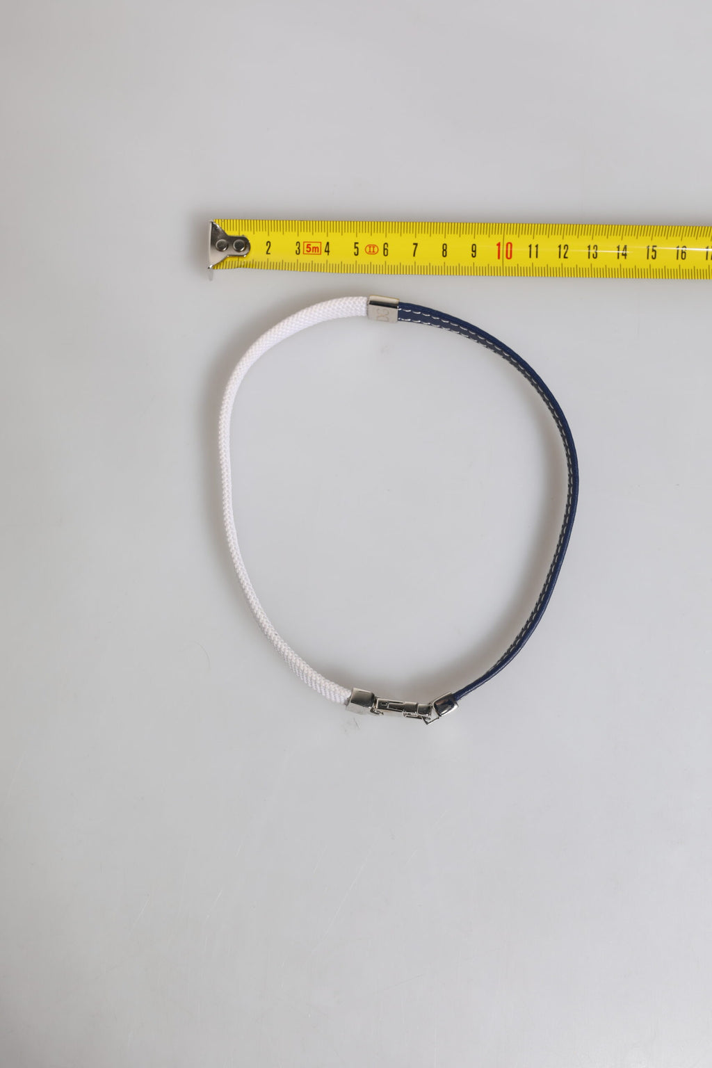 Armband mit silberfarbenem Verschluss und blau-weißem Lederbesatz mit DG-Gravur