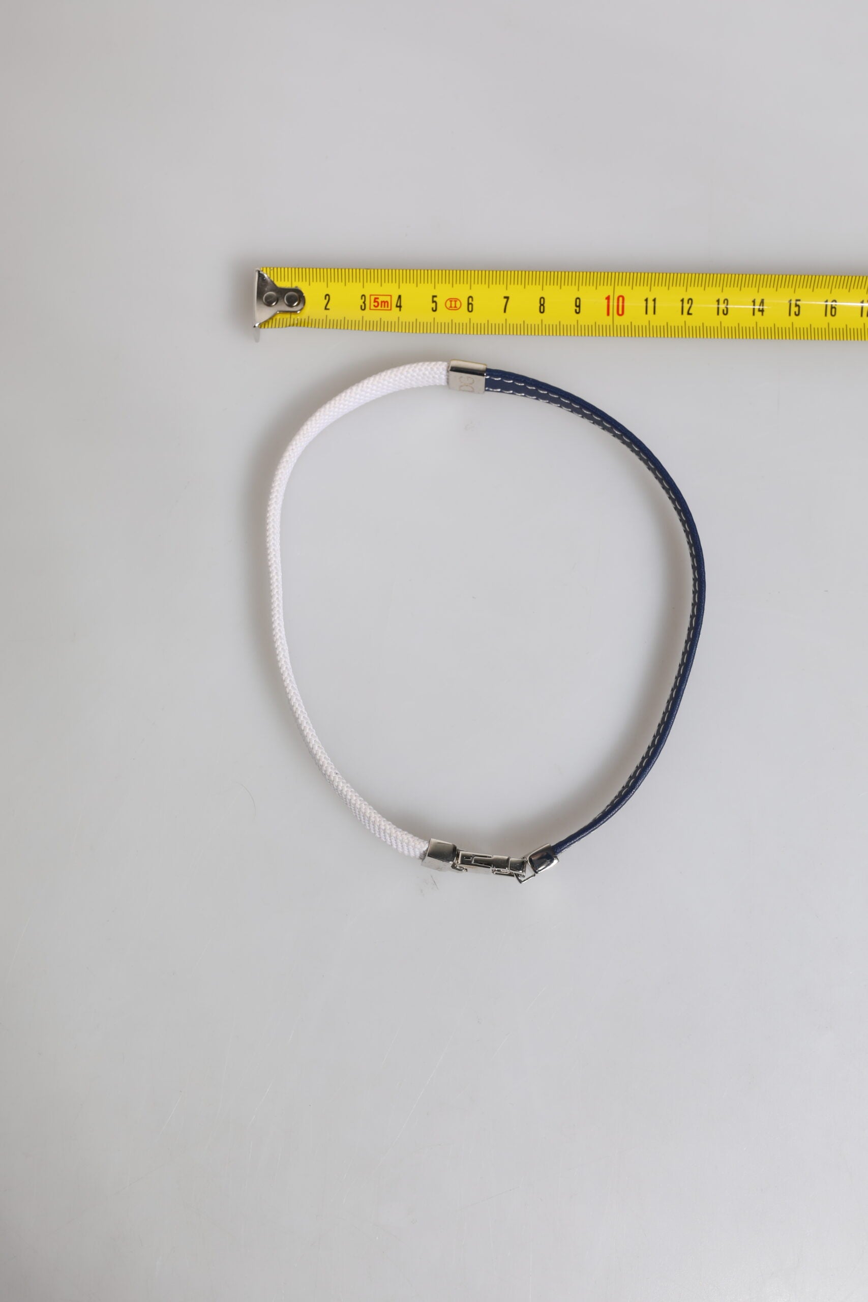 Armband mit silberfarbenem Verschluss und blau-weißem Lederbesatz mit DG-Gravur