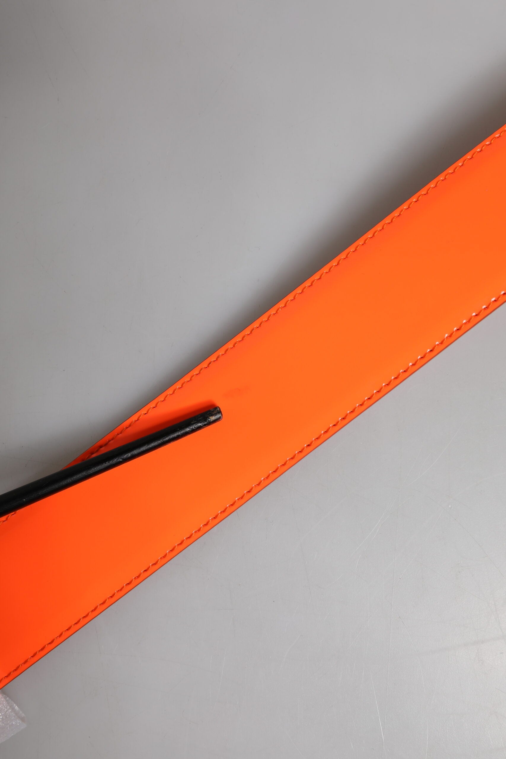 Orangefarbener Gürtel mit goldfarbener Logoschnalle aus Metall