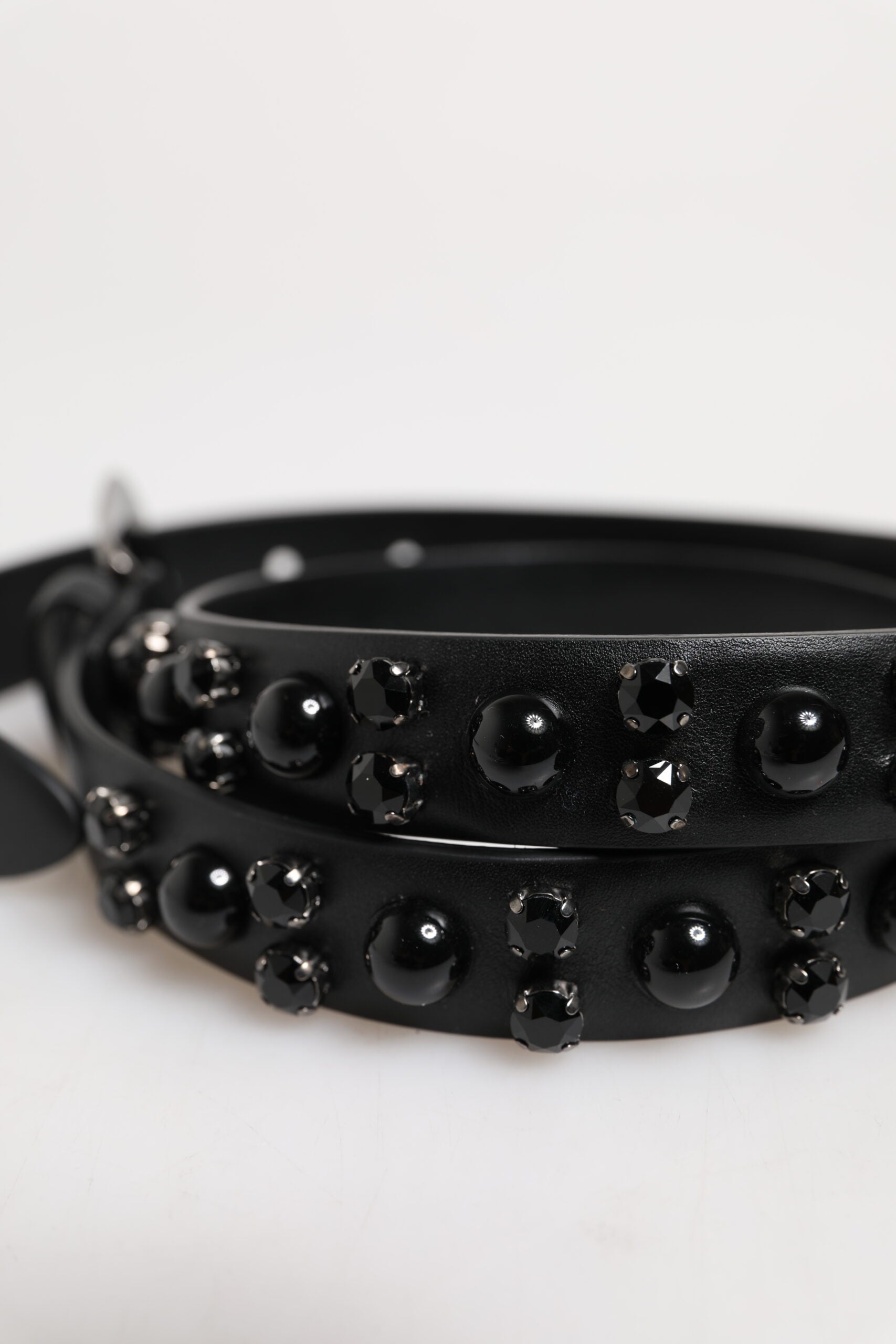 Schwarzer Ledergürtel mit Metall-Logoschnalle und Nieten