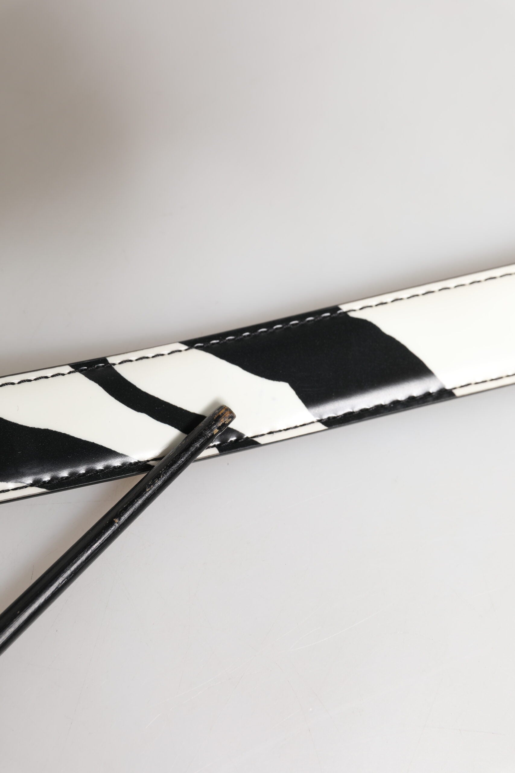 Schwarz-weißer Ledergürtel mit silberner Metallschnalle